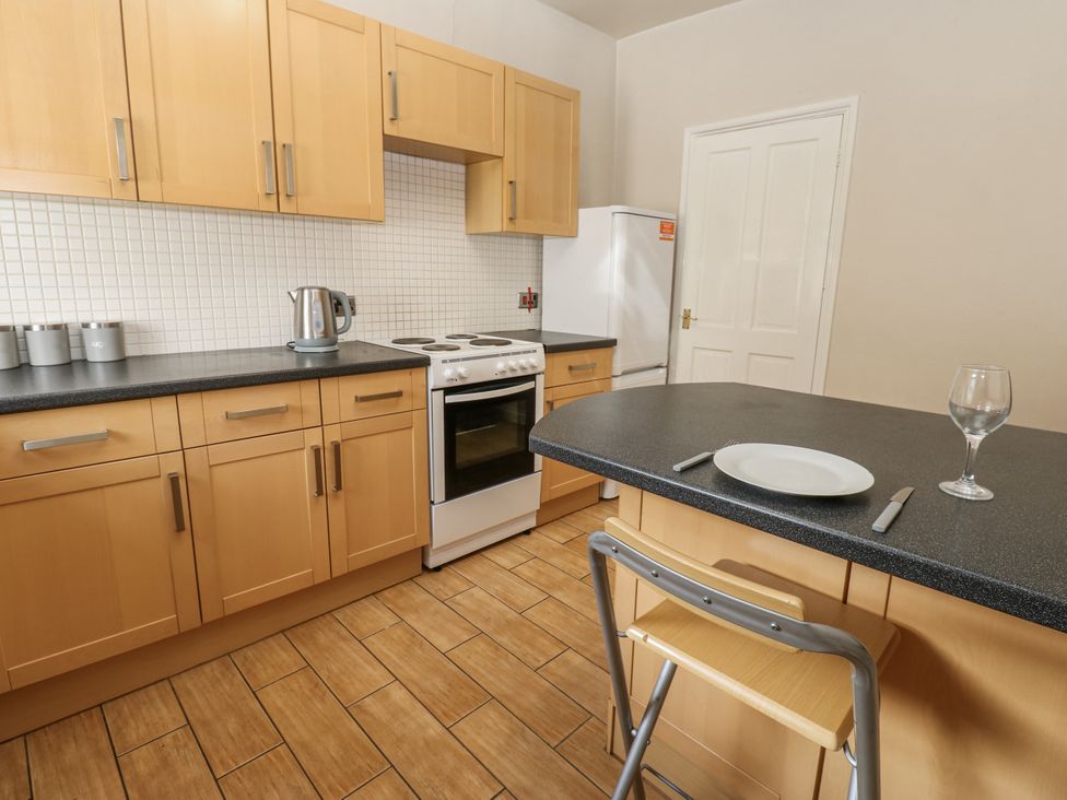 A kitchen with cabinets, stove, and countertop at Cumberland House Workington