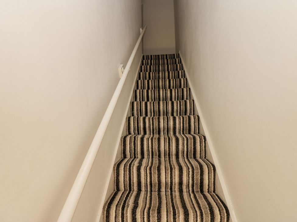 A stairway with carpet and a handrail at Cumberland House in Workington