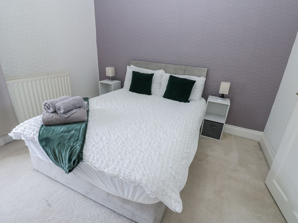 A bedroom with a bed and bedside tables at Cumberland House in Workington