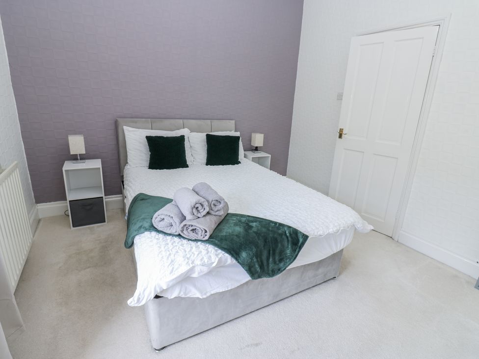 A bedroom with a bed and bedside tables at Cumberland House in Workington