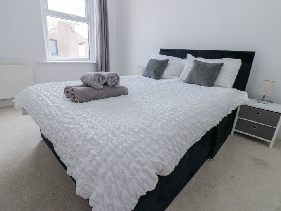 A bedroom with a bed and towels at Cumberland House in Workington