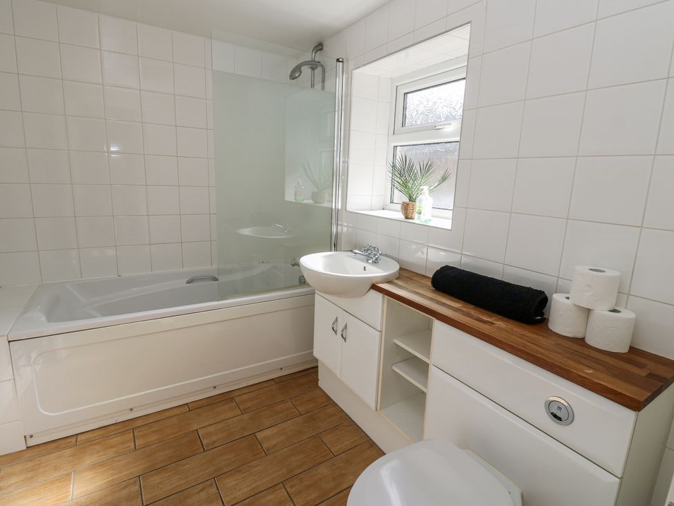 A bathroom with a bathtub, sink, and toilet at Cumberland House, Workington