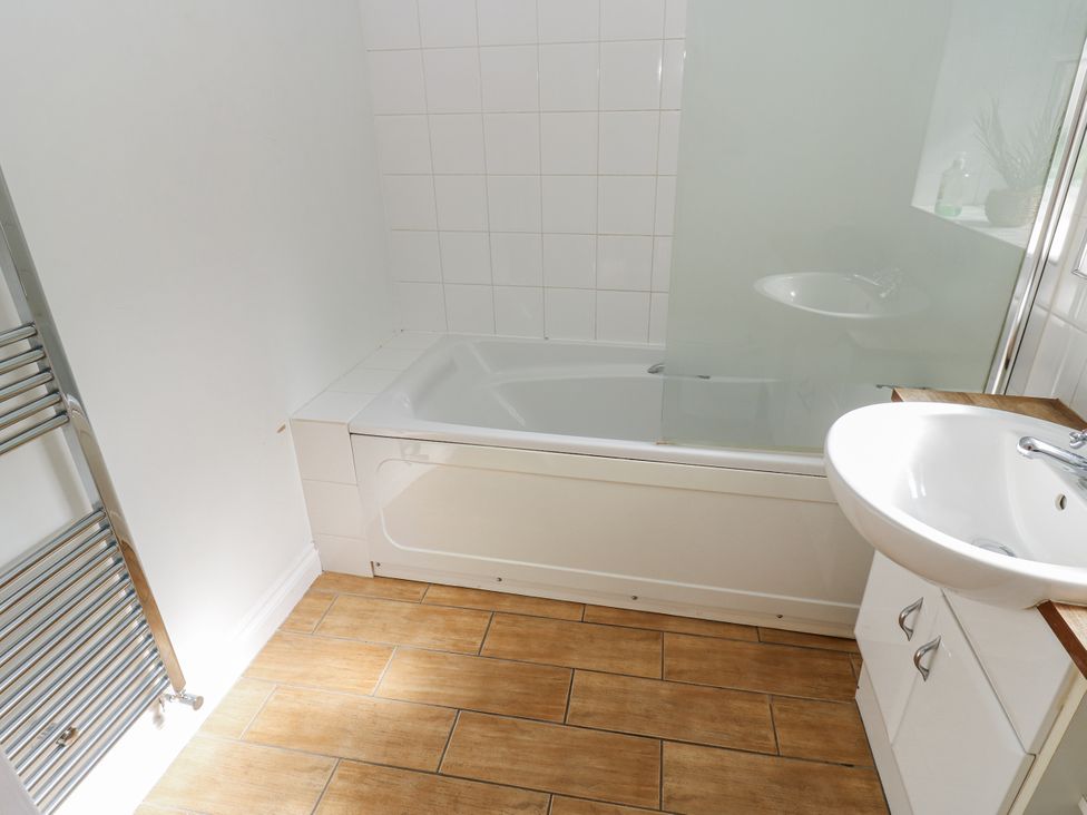 A bathroom with a bathtub and sink at Cumberland House in Workington
