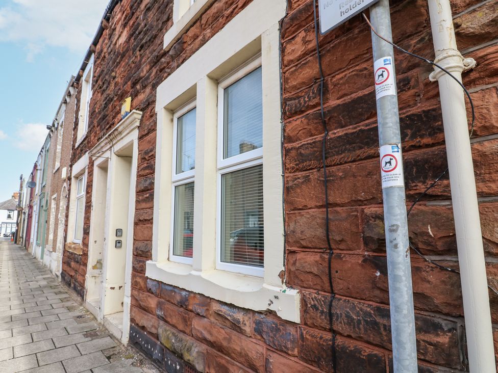 A view of a brick wall with windows and a door at Cumberland House in Workington