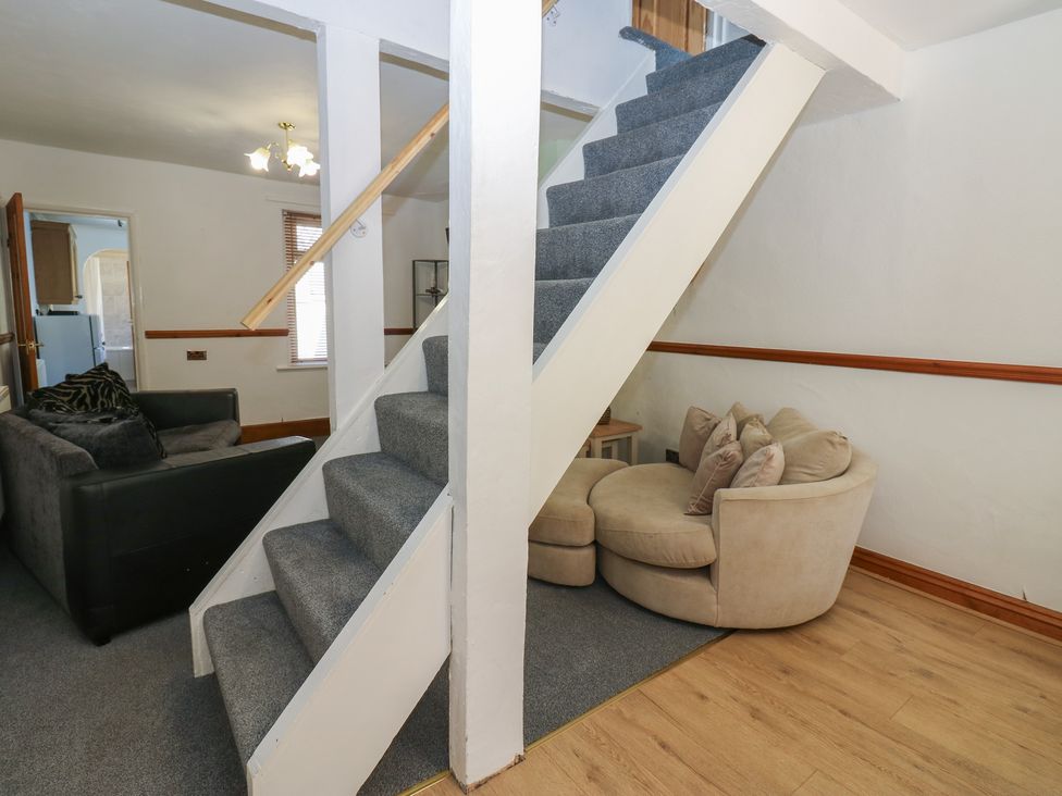 A living room with a staircase and seating at Bolton Terrace in Workington