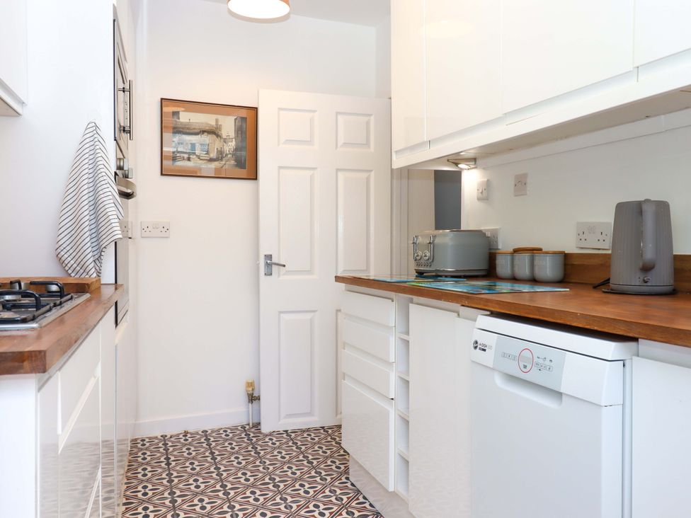 A kitchen with appliances and cabinets at Kenny Cottage in Dawlish