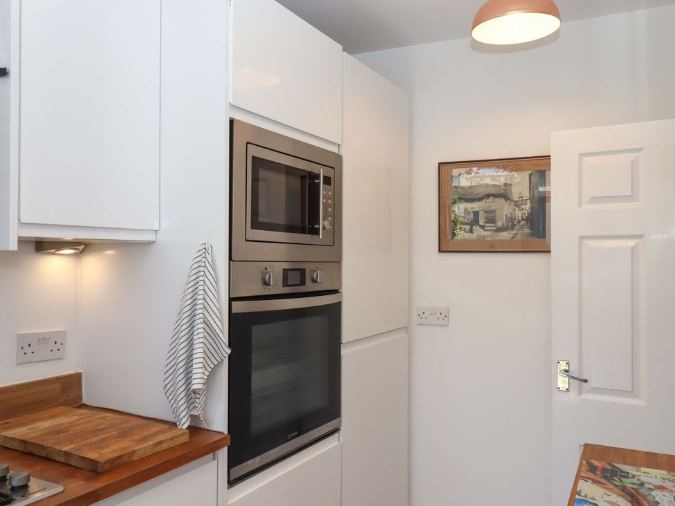 A kitchen with an oven and microwave at Kenny Cottage in Dawlish
