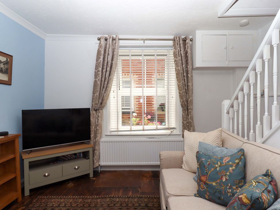 A living room with a sofa and television at Kenny Cottage in Dawlish