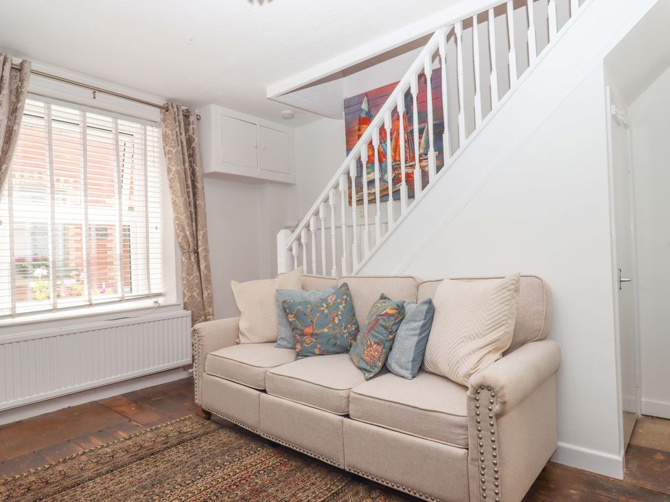 A living room with a sofa and rug at Kenny Cottage in Dawlish