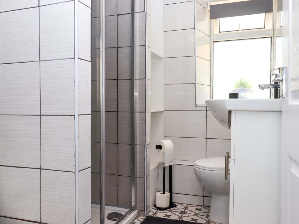 A bathroom with a shower, toilet, and sink at Kenny Cottage in Dawlish