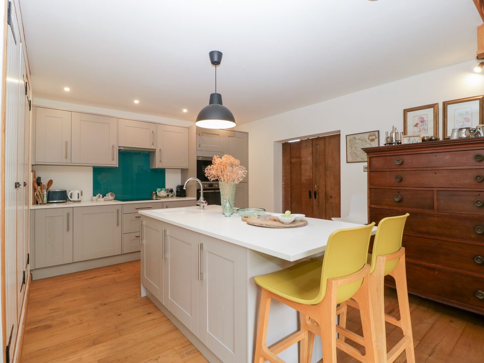 A kitchen with cabinets and bar stools at The Art House in Leominster