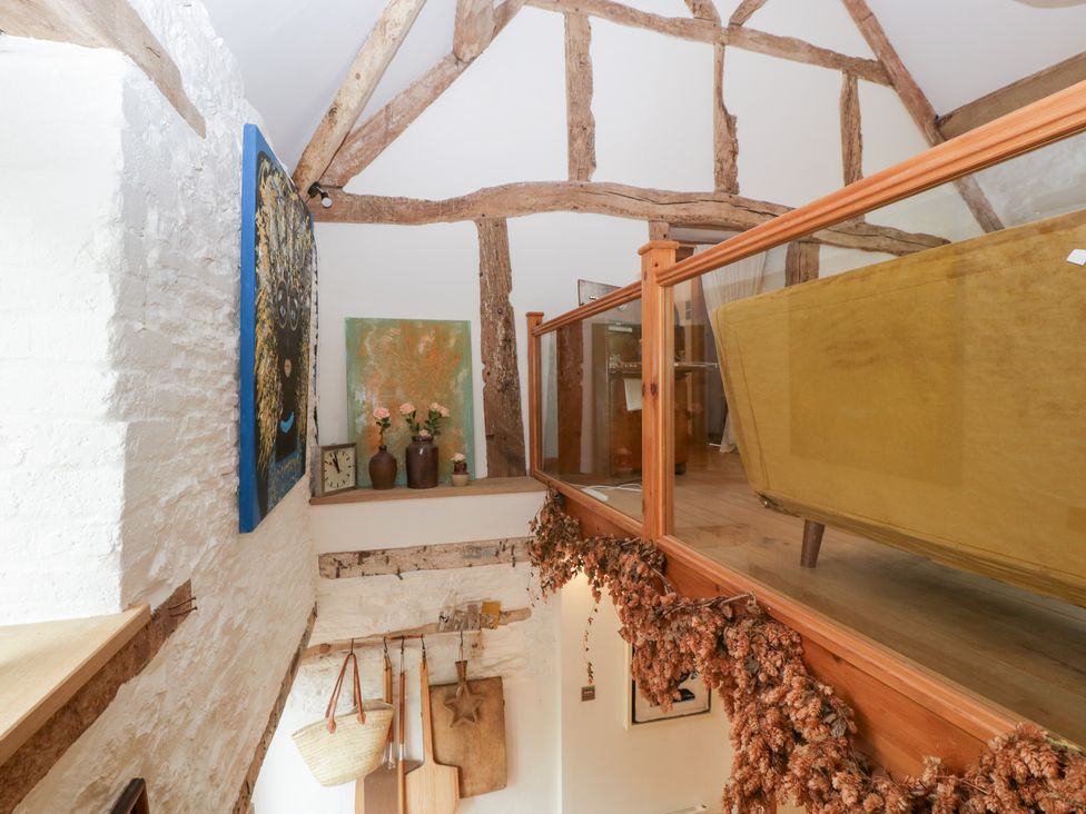 A living room with wooden beams and decorative items at The Art House in Leominster