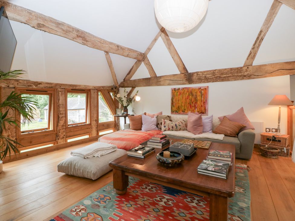 A living room with a sofa, coffee table, and windows at The Art House in Leominster