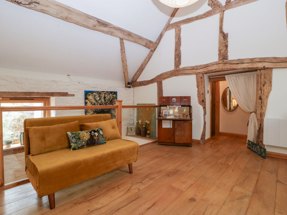 A living room with a sofa and wooden beams at The Art House in Leominster