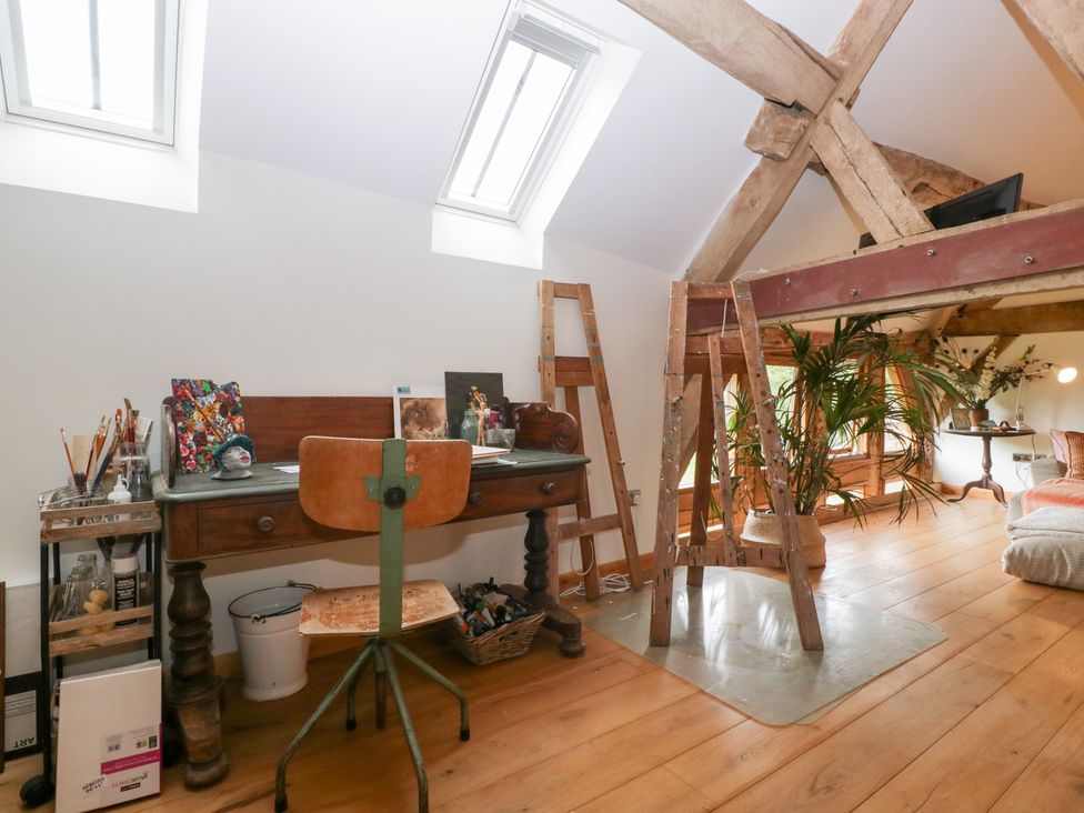 A studio with a desk, chair, and easel at The Art House in Leominster
