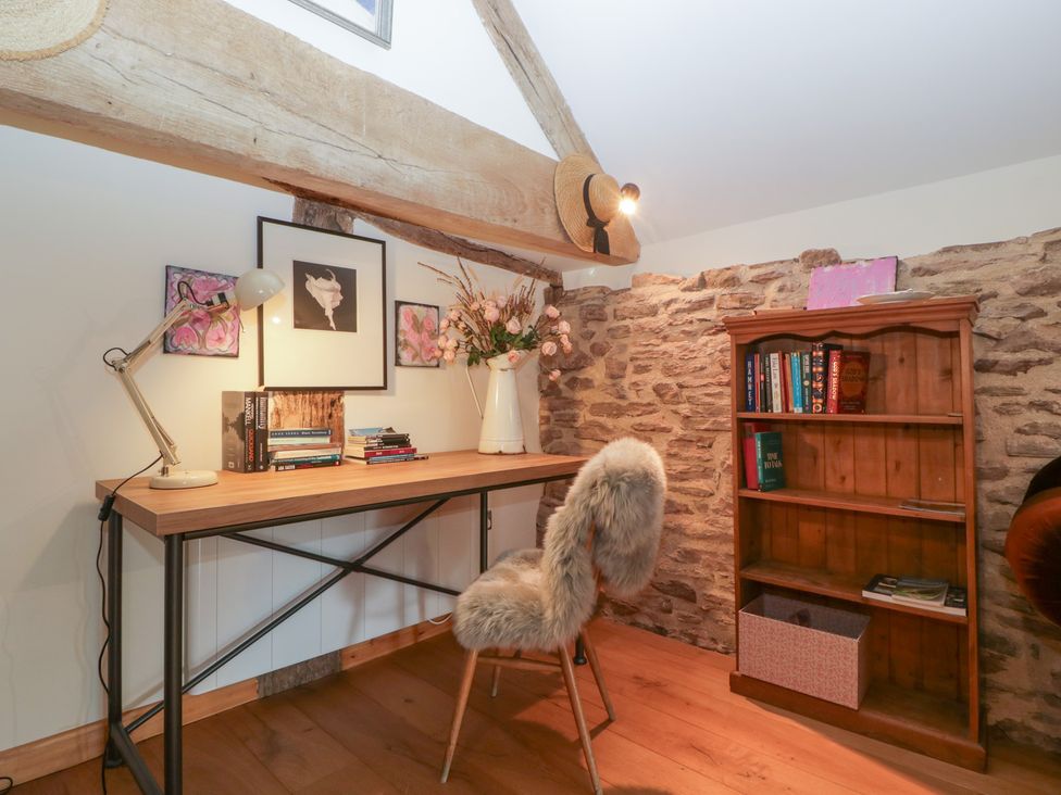 A home office with a desk and books at The Art House in Leominster