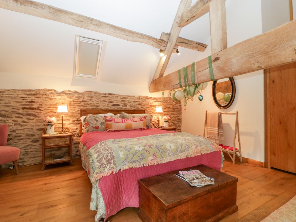 A bedroom with a bed, nightstand, and wooden beams at The Art House in Leominster