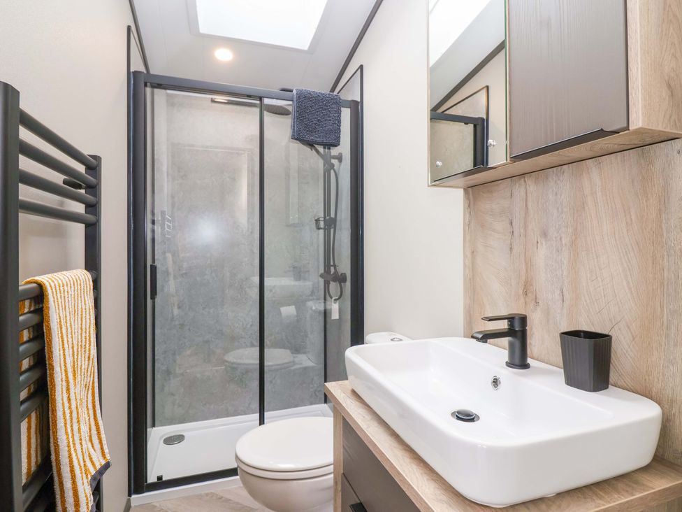 A bathroom with a shower and sink at Hazelnut Lodge in Chipping Norton