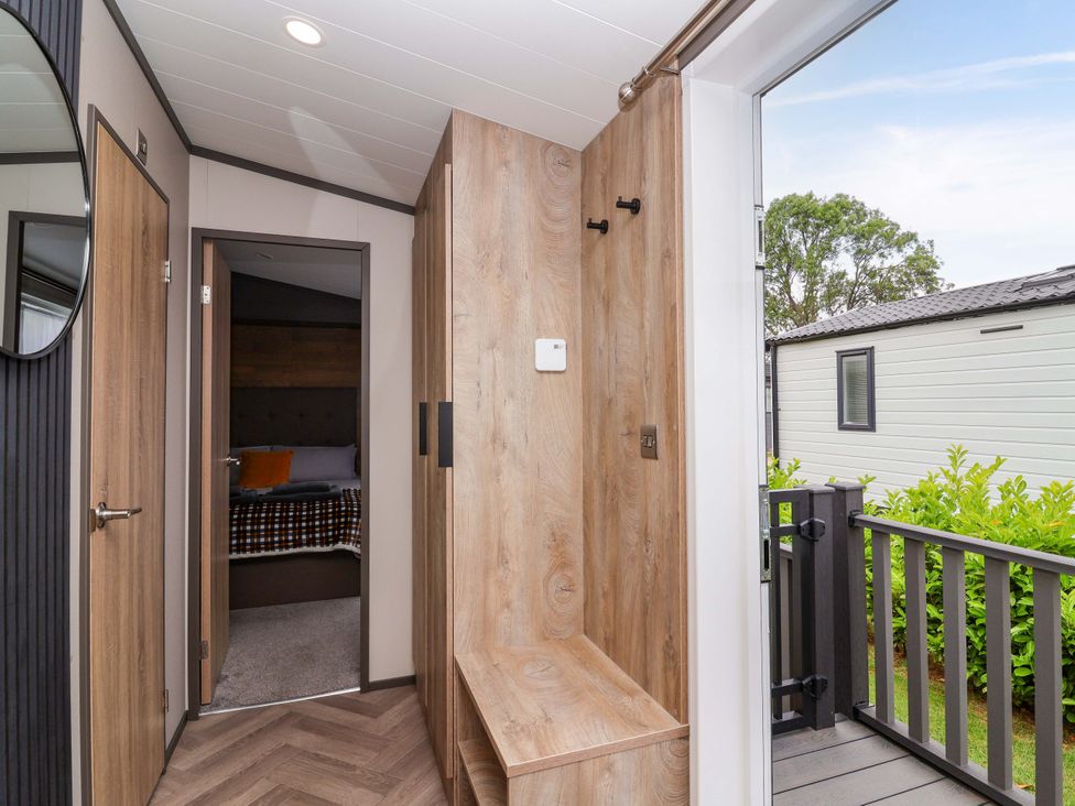 A hallway with a mirror and a sitting area at Hazelnut Lodge in Chipping Norton