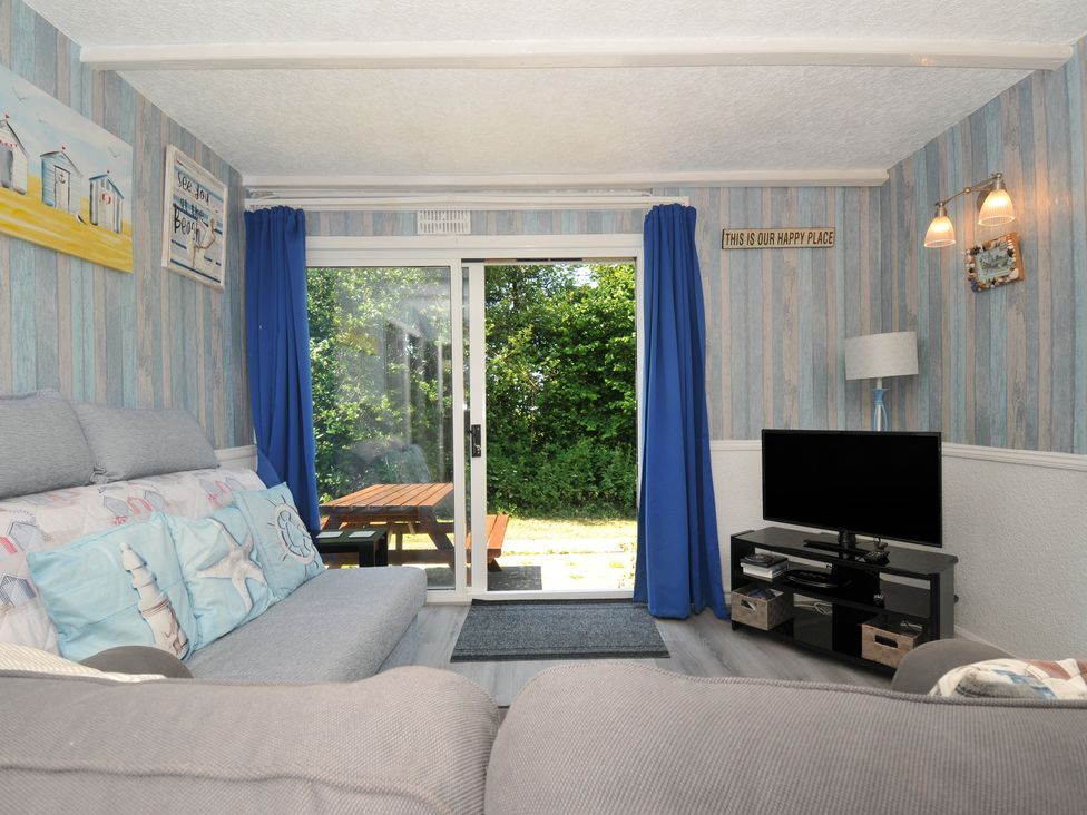 A snug with a sofa and a tv at 8 Hillside in Bude