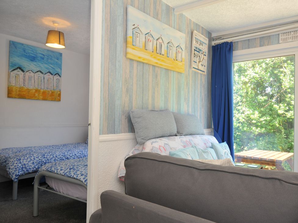 A living room with a bed and sofa at 8 Hillside Bude