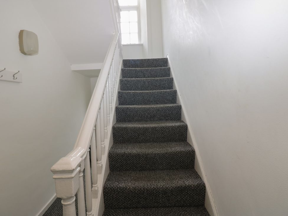 A staircase with carpet and handrail at Georgian Town House in Whitehaven