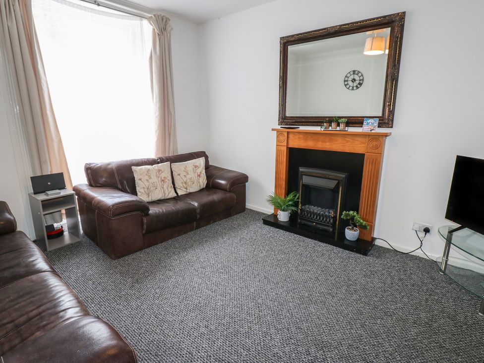 A living room with a fireplace and mirror at Georgian Town House in Whitehaven