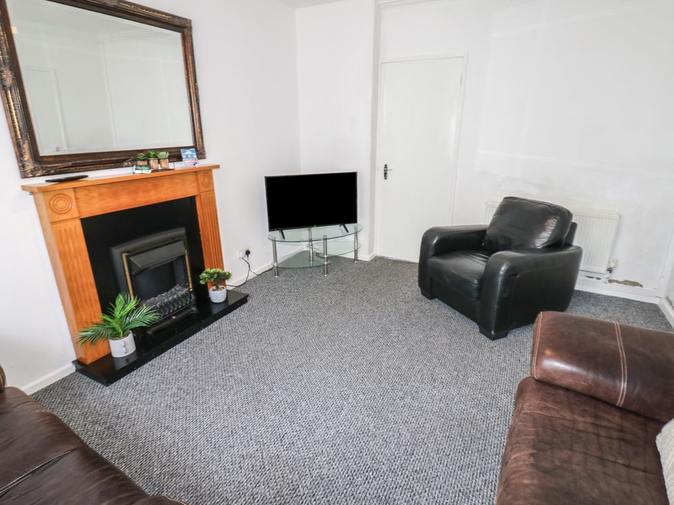 A living room with a television and fireplace at Georgian Town House in Whitehaven