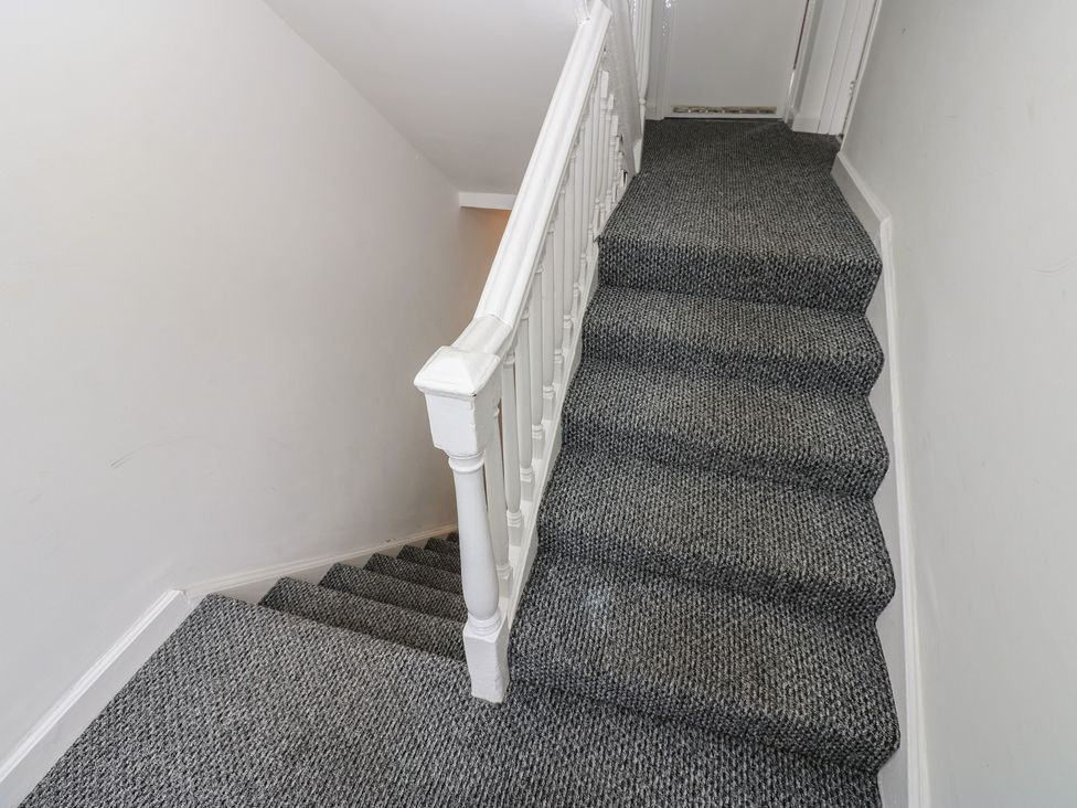 A staircase with a white handrail and carpet at Georgian Town House in Whitehaven