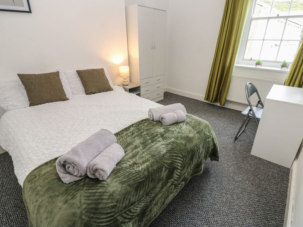 A bedroom with a bed and wardrobe at Georgian Town House in Whitehaven