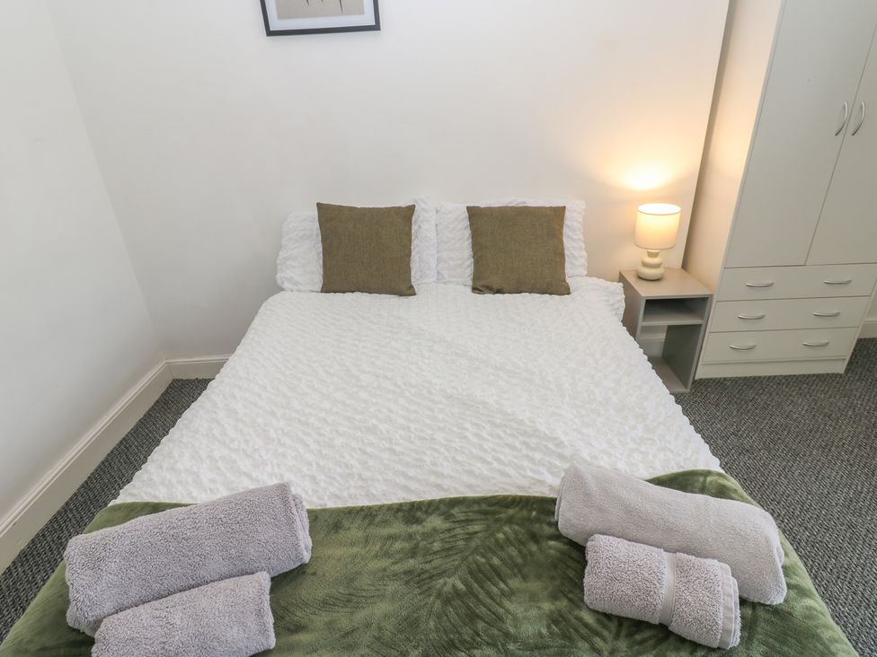 A bedroom with a bed and towels at Georgian Town House in Whitehaven