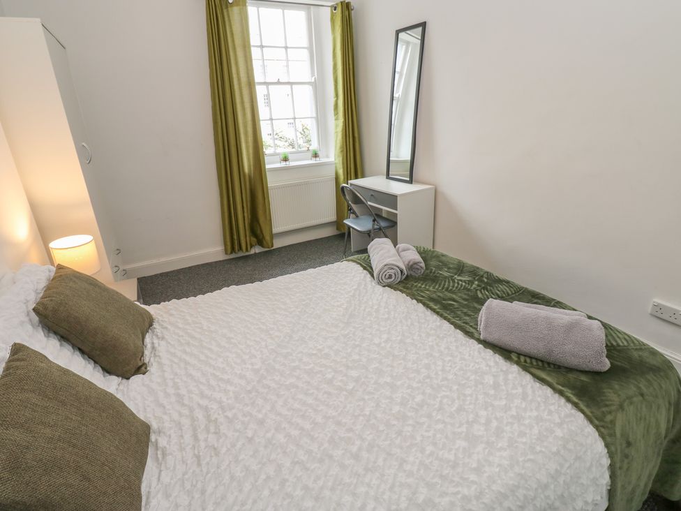A bedroom with a bed and a desk at Georgian Town House in Whitehaven