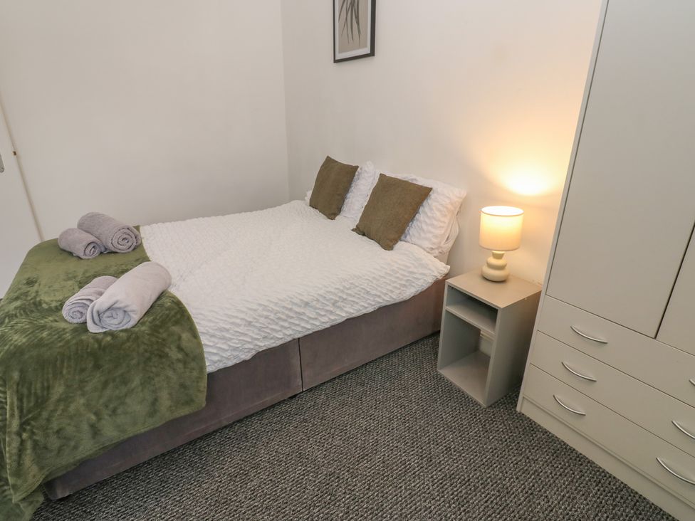A bedroom with a bed and nightstand at Georgian Town House in Whitehaven