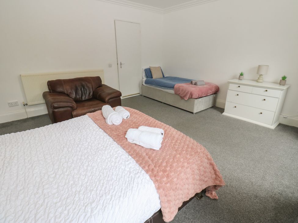 A bedroom with a bed, sofa and dresser at Georgian Town House in Whitehaven