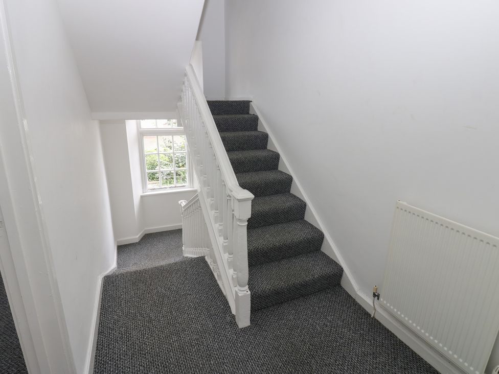 A staircase with a window and radiator at Georgian Town House in Whitehaven