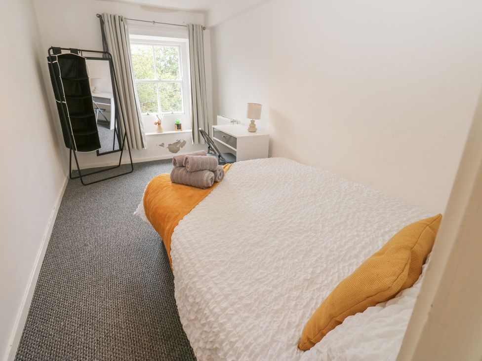 A bedroom with a bed and a mirror at Georgian Town House in Whitehaven