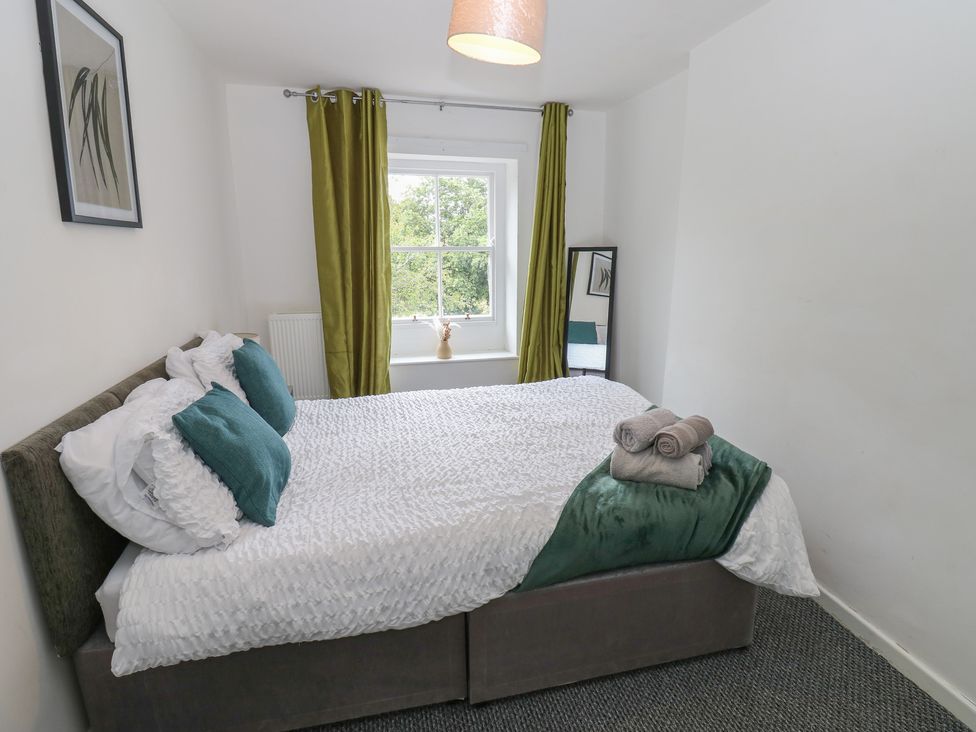 A bedroom with a bed and towels at Georgian Town House in Whitehaven