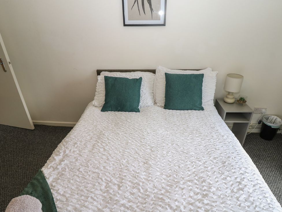 A bedroom with a bed and bedside lamp at Georgian Town House Whitehaven