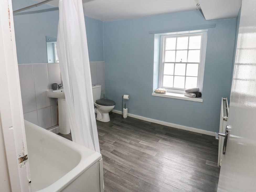 A bathroom with a bathtub, toilet, and sink at Georgian Town House in Whitehaven