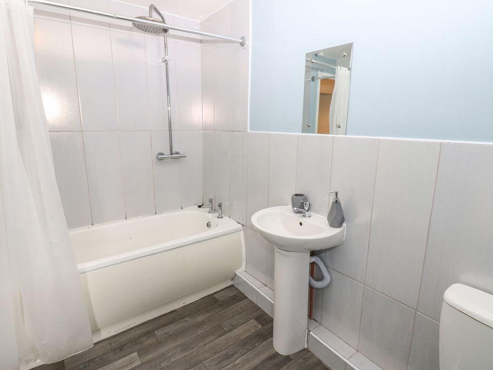 A bathroom with a bathtub, sink, and toilet at Georgian Town House in Whitehaven