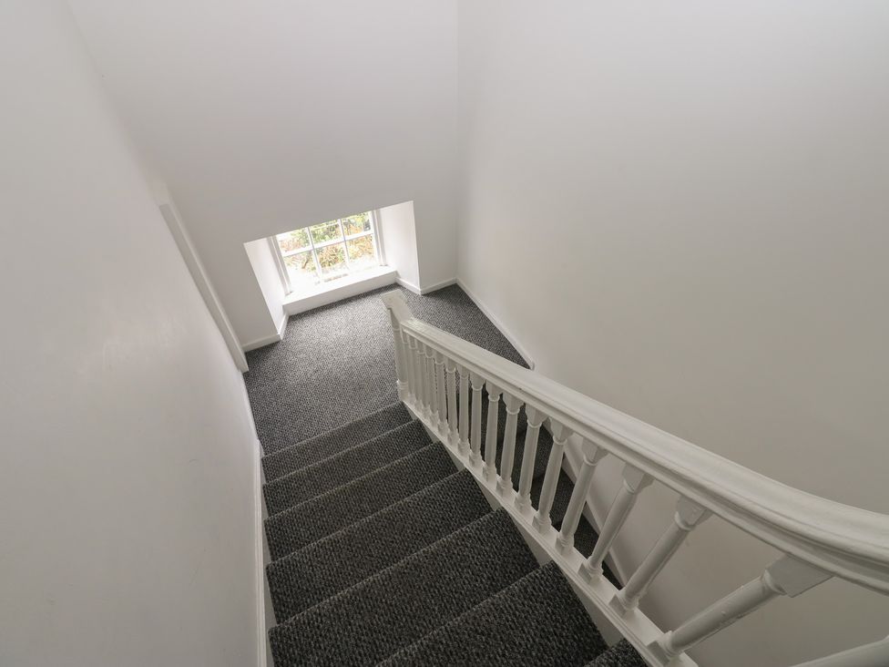 A staircase with a handrail and a window at Georgian Town House in Whitehaven