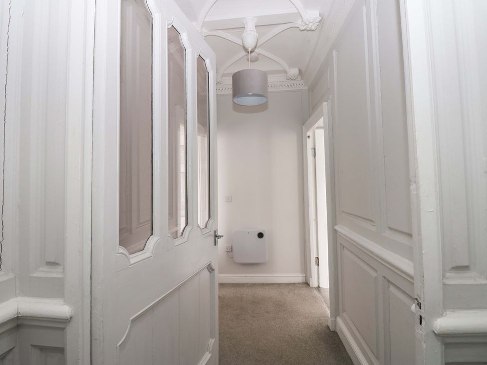 A hallway with a door and a light fixture at Lowther Suite Whitehaven