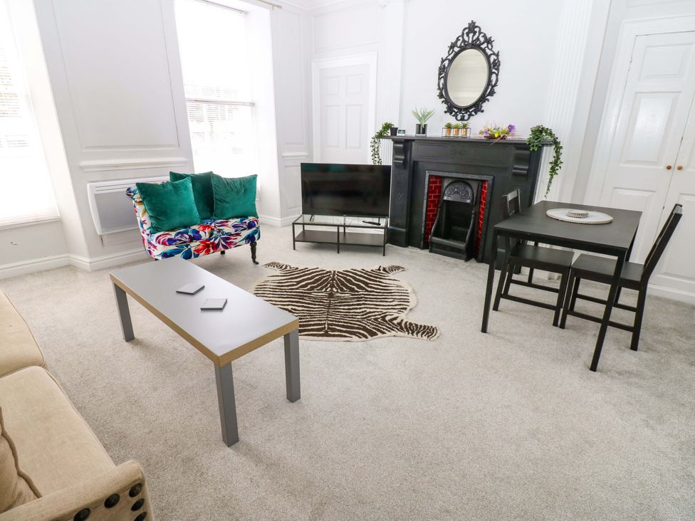 A living room with a coffee table and sofa at Lowther Suite in Whitehaven