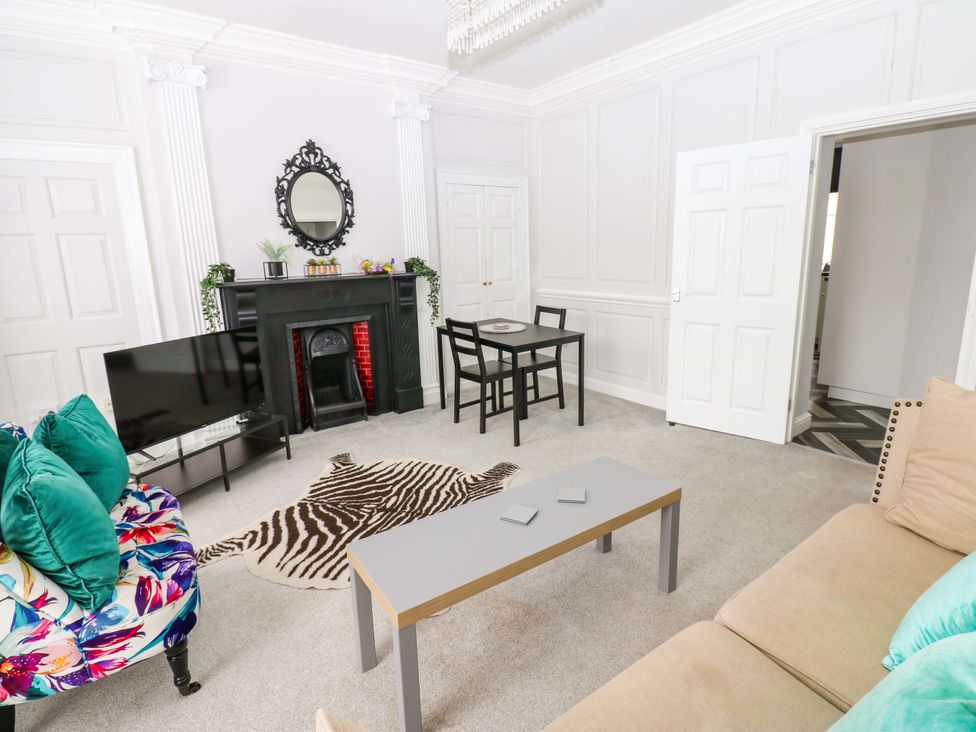 A living room with a sofa and a coffee table at Lowther Suite in Whitehaven