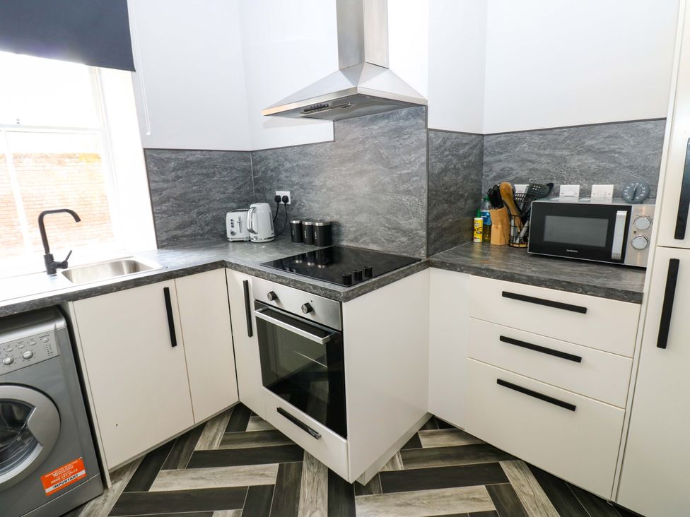 A kitchen with stove and microwave at Lowther Suite in Whitehaven