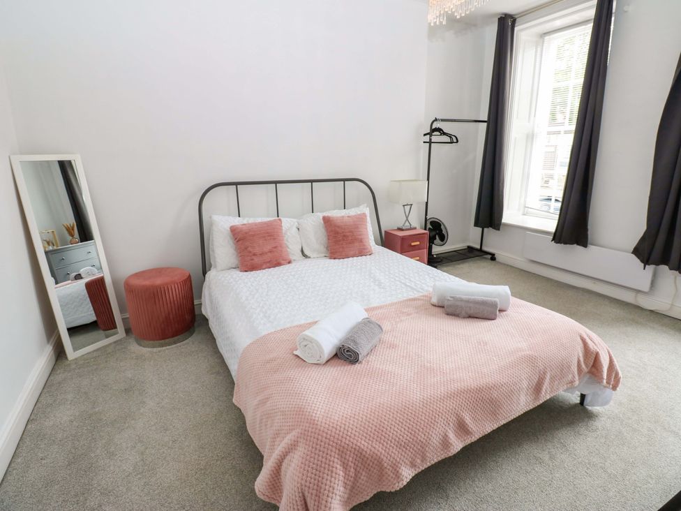 A bedroom with a bed and mirror at Lowther Suite in Whitehaven