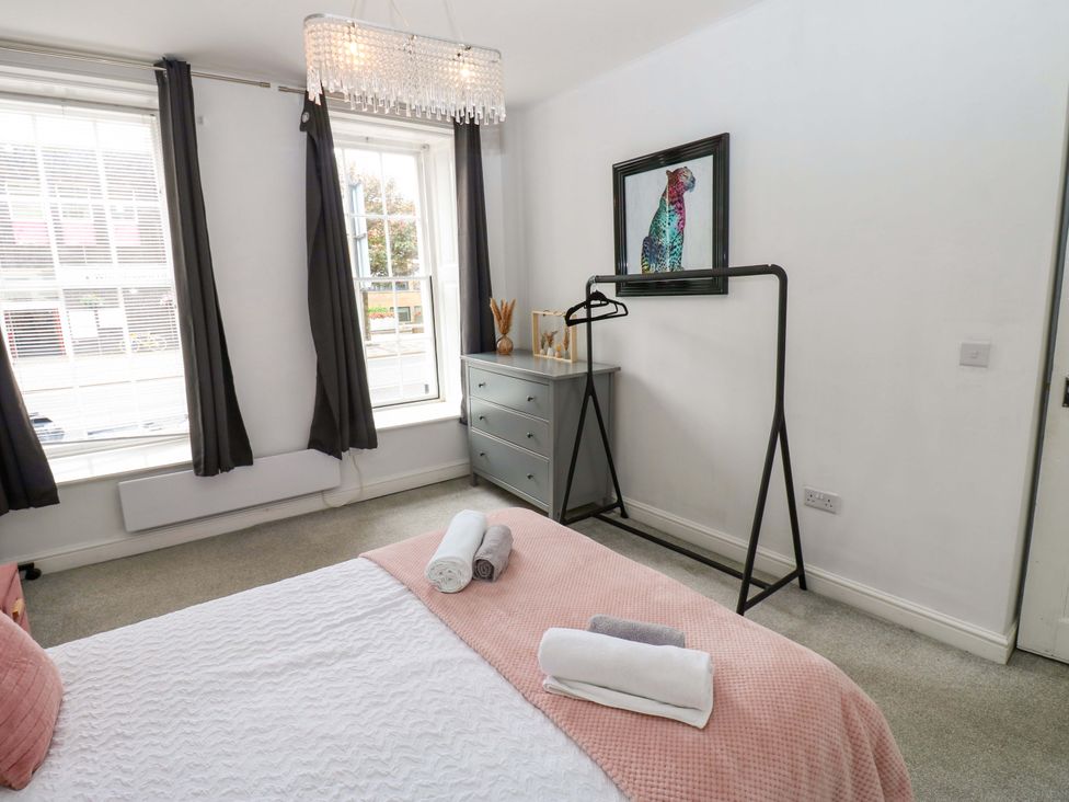 A bedroom with a bed and a dresser at Lowther Suite in Whitehaven