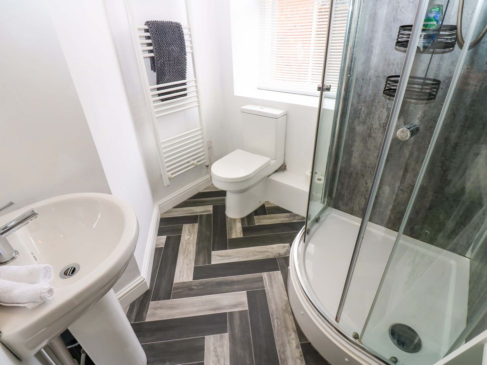 A bathroom with a shower, toilet, and sink at Lowther Suite in Whitehaven