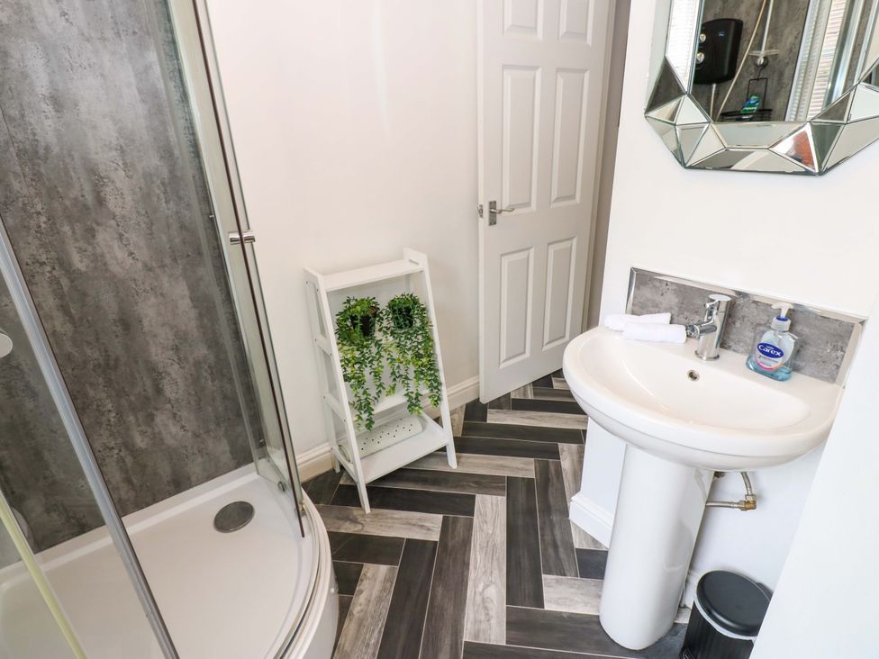 A bathroom with a shower and sink at Lowther Suite in Whitehaven