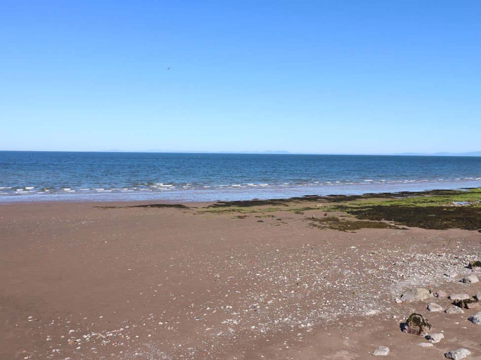 A beach with sand and sea at Lowther Suite in Whitehaven